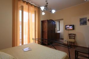 a room with a table and a chair and a television at Affittacamere Casa di Elide in Fondi