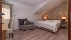 een slaapkamer met een bed en een stoel bij Villa Lučica Trogir in Trogir