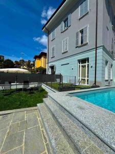 a house with a swimming pool next to a building at Apt. Aquarius Oasi di Menaggio in Menaggio