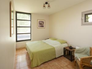 a bedroom with a bed and a window and a chair at Holiday Home Villa Isabelle by Interhome in Gondonnets
