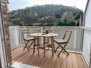 a table with two chairs and a bottle of wine on a balcony at Apartment An der Eine-1 by Interhome in Stangerode