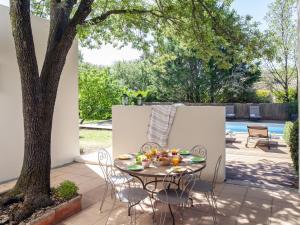 a patio with a table and chairs and a tree at Holiday Home Villa Isabelle by Interhome in Gondonnets