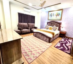 Hayyat Luxury Apartments في لاهور: غرفة نوم مع سرير مزدوج كبير وأريكة