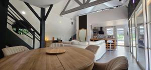 sala de estar con mesa de madera y sofá en Villa des Virages - 5 min du circuit du Mans, en Mulsanne