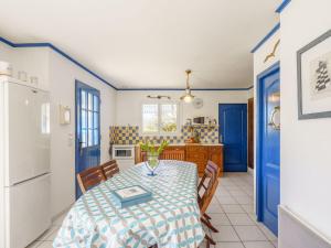 kuchnia ze stołem i krzesłami oraz niebieskimi drzwiami w obiekcie Holiday Home Ty Bihan - LOY114 by Interhome w mieście Loctudy