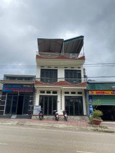a building with two motorcycles parked in front of it at Motel Homestay Tiến Học in Mia Xu