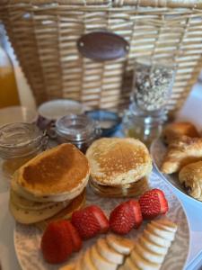 a plate with pancakes and strawberries on a table at Côte & Lodge in Talais