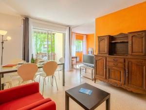 Una sala de estar con un sofá rojo y un televisor. en Apartment Pré Catelan-1 by Interhome, en Saint-Georges-de-Didonne