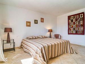 een slaapkamer met een bed met een gestreepte deken bij Holiday Home Villa Faro - MFT100 by Interhome in Montfort-sur-Argens