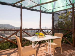 a table and chairs on a deck with a view at Apartment Limoneto a Priora by Interhome in Massa Lubrense