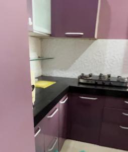 a kitchen with purple cabinets and a stove at 30th floor 2BHK near Viviana Mall with Balcony & Car Parking in Thane