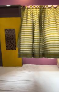 a bedroom with a bed and a yellow wall at 30th floor 2BHK near Viviana Mall with Balcony & Car Parking in Thane