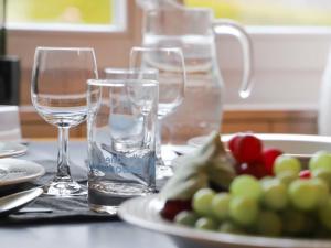 deux verres d'eau et une assiette de fruits sur une table dans l'établissement Apartment Suzanne Nr- 21 by Interhome, à Gstaad