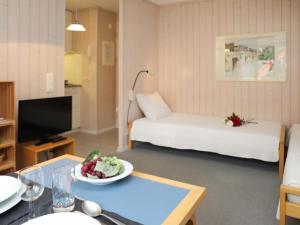 een woonkamer met een bed en een tafel bij Apartment Suzanne Nr- 21 by Interhome in Gstaad