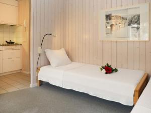 ein Schlafzimmer mit einem Bett mit einer Blume darauf in der Unterkunft Apartment Suzanne Nr- 21 by Interhome in Gstaad
