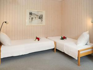 2 Betten in einem Zimmer mit Blumen darauf in der Unterkunft Apartment Suzanne Nr- 21 by Interhome in Gstaad