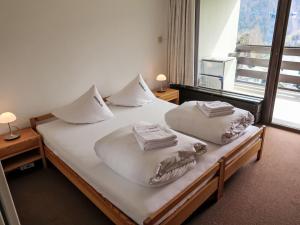een slaapkamer met een bed met 2 kussens erop bij Apartment Utoring Acletta-105 by Interhome in Disentis