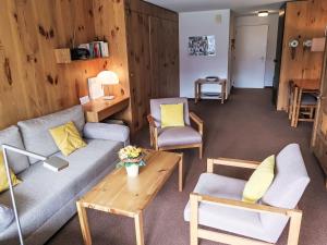 een woonkamer met een bank, stoelen en een tafel bij Apartment Utoring Acletta-105 by Interhome in Disentis