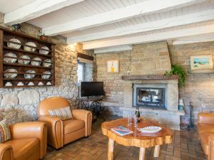 un soggiorno con divani e camino in pietra di Holiday Home Bienvenue - LOY102 by Interhome a Loctudy