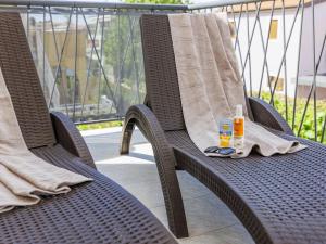 - une chaise en osier avec une serviette et 2 bouteilles de crème solaire dans l'établissement Apartment Marina - NVG115 by Interhome, à Novigrad