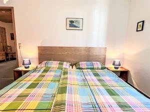 1 dormitorio con 1 cama con un edredón colorido en Apartment Sonnenblick III by Interhome en Büreten