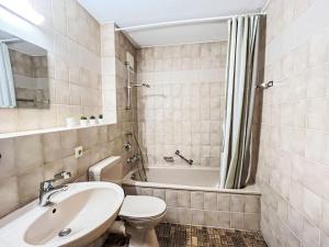 a bathroom with a sink and a toilet and a tub at Apartment Sonnenblick III by Interhome in Büreten