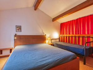 a bedroom with two beds and a red curtain at Holiday Home Les As-2 by Interhome in Lacanau-Océan