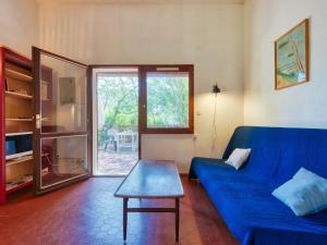 a living room with a blue couch and a table at Holiday Home Les As-2 by Interhome in Lacanau-Océan