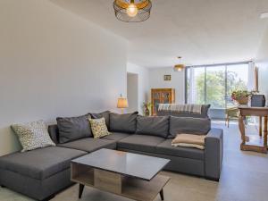ein Wohnzimmer mit einem grauen Sofa und einem Tisch in der Unterkunft Holiday Home La Grive - RCH100 by Interhome in Richerenches