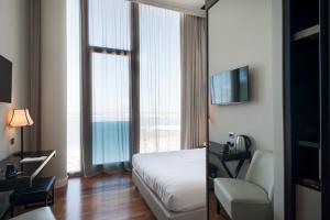 a hotel room with a bed and a view of the ocean at SeePort Hotel in Ancona