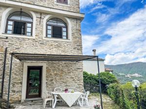a stone house with a table and chairs at Apartment Appartamento 1 by Interhome in Tavole