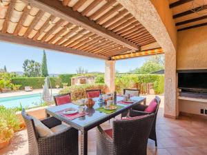 a patio with a table and chairs and a pool at Holiday Home Le Mas d'Olive - GRI230 by Interhome in Grimaud