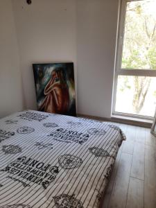 a bedroom with a bed with a painting on the wall at Апартамент Лятно изкушение in Balchik