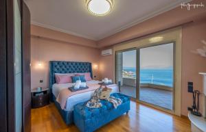 - une chambre avec un grand lit et une grande fenêtre dans l'établissement Anemou Nota Villa-Luxury Resort, à Ambelón