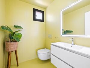 a bathroom with a sink and a toilet and a mirror at Villa Megin by Interhome in Cumbre del Sol