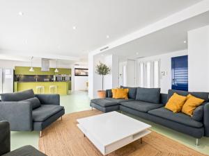 sala de estar con sofá azul y almohadas amarillas en Villa Megin by Interhome, en Cumbre del Sol