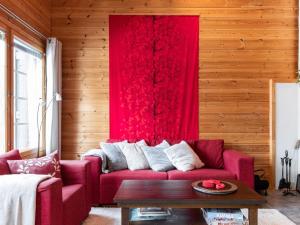 ユッラスヤルヴィにあるHoliday Home Kultapiisku 2 by Interhomeのリビングルーム(赤いソファ、赤いカーテン付)