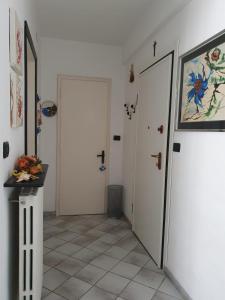 a hallway with two white doors and a tile floor at [Casa Tizzy] Frontemare in Borghetto Santo Spirito