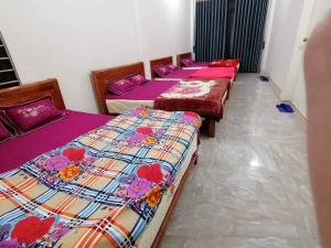 four beds lined up in a row in a room at Motel Homestay Tiến Học in Mia Xu