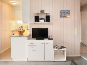 una cucina con bancone e TV di Apartment Arlette Nr- 34 by Interhome a Gstaad Altre 13 foto