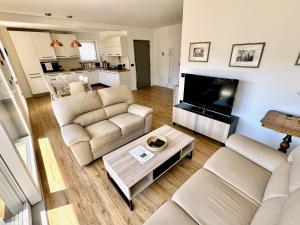 a living room with two couches and a flat screen tv at Villa Dada in Predazzo