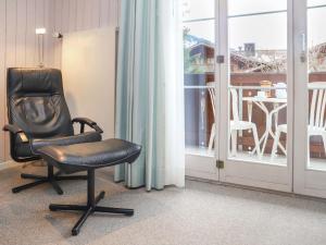 a black chair sitting in front of a window at Apartment Arlette Nr- 34 by Interhome in Gstaad