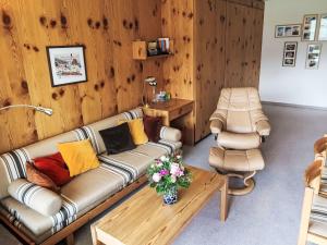een woonkamer met een bank en een salontafel bij Apartment Utoring Acletta-63 by Interhome in Disentis