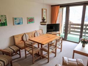 een eetkamer met een houten tafel en stoelen bij Apartment Utoring Acletta-63 by Interhome in Disentis