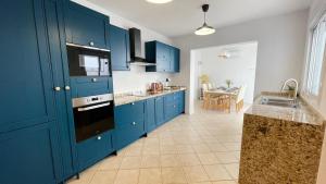 a blue kitchen with a sink and a stove at Casa Azahar luxury ground floor apartment in Alhaurín el Grande