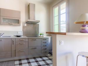 a kitchen with stainless steel appliances and a checkered floor at Apartment Le Victor Hugo by Interhome in Nice