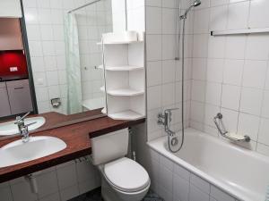 a bathroom with a toilet and a sink and a bath tub at Apartment Apt B 093 by Interhome in Disentis