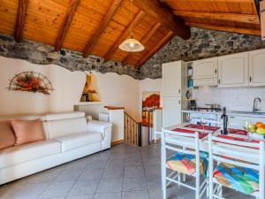 eine Küche und ein Wohnzimmer mit einem weißen Sofa in der Unterkunft Holiday Home Pieve - GRV102 by Interhome in Gravedona
