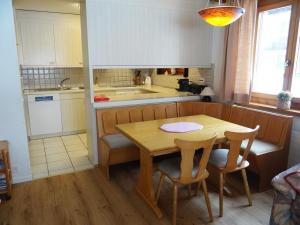 una pequeña cocina con mesa de madera y sillas en Apartment Blumenweg 6 by Interhome, en Engelberg