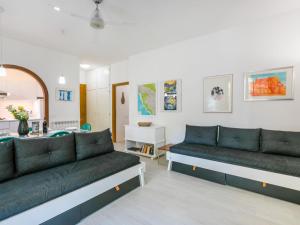 ein Wohnzimmer mit 2 Sofas und einer Küche in der Unterkunft Apartment I Pini by Interhome in Castiglioncello